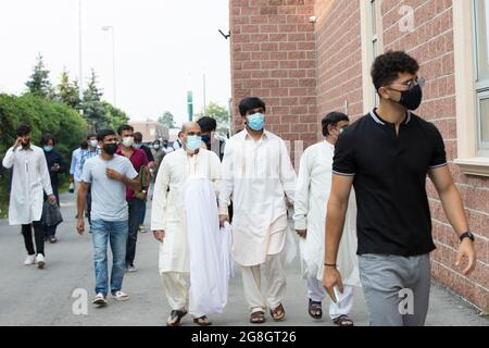 Eine Gruppe islamischer Männer geht zum Abschied von Premierminister Justin Trudeau, der während der Eid-Zeit in der Moschee eine Rede hält, auf die Rückseite der Moschee Stockfoto