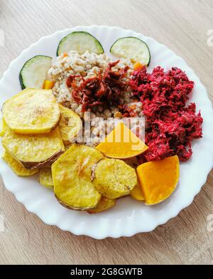 Perlgerste mit Sojabohnen, Karotten, getrockneten Tomaten. Gebackene Kartoffeln, Kürbis und Zucchini. Salat mit Rote Beete Stockfoto