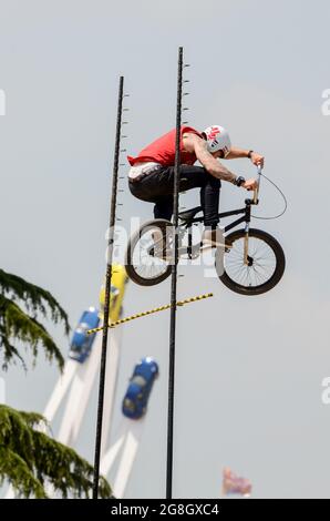 BMX-Hochsprung-Stunt-Fahrer beim Goodwood Festival of Speed in Großbritannien, der mit Porsche 50 im Zentrum Luft über die Sprungstange holt. Extremsport Stockfoto