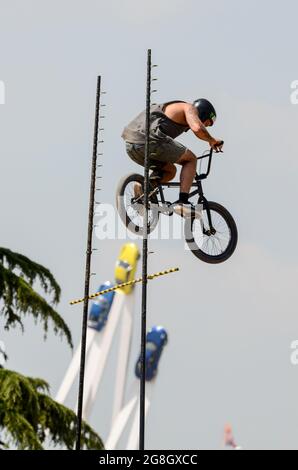 BMX-Hochsprung-Stunt-Fahrer beim Goodwood Festival of Speed in Großbritannien, der mit Porsche 50 im Zentrum Luft über die Sprungstange holt. Extremsport Stockfoto