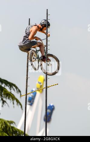 BMX-Hochsprung-Stunt-Fahrer beim Goodwood Festival of Speed in Großbritannien, der mit Porsche 50 im Zentrum Luft über die Sprungstange holt. Extremsport Stockfoto