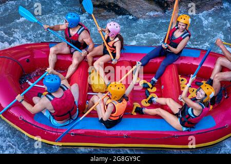 Gruppe von Touristen, die mit dem starken Strom des Gebirgsflusses kämpfen. Stockfoto