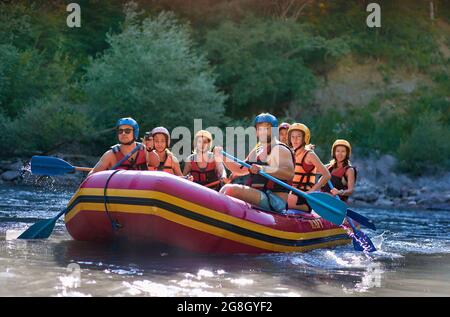 Gruppe von Touristen, die mit dem starken Strom des Gebirgsflusses kämpfen. Stockfoto