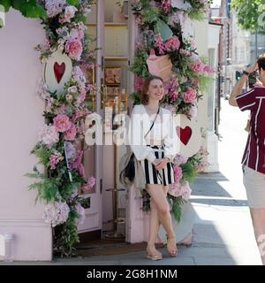 London, Greater London, England, Juni 12 2021: Junge Frau im schwarz-weißen Minirock lächelt und posiert für ein Foto auf der Kings Road. Stockfoto