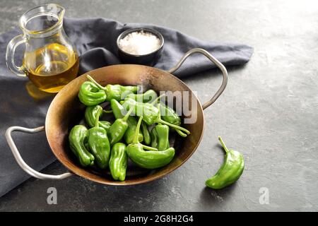 Pimientos, kleine grüne Paprika de padron in einer eisernen Pfanne, in Spanien werden sie in Olivenöl gebraten, mit Meersalz bestreut und als Vorspeise oder als t serviert Stockfoto