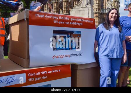 London, Großbritannien. Juli 2021. Während der Demonstration gegenüber dem parlament steht ein Protestler neben großen NHS-Petitionsboxen. Gewerkschaftsmitglieder, NHS-Mitarbeiter und Unterstützer versammelten sich in Westminster, um eine Lohnerhöhung von 15 % für alle NHS-Beschäftigten zu fordern, nachdem die Regierung eine Erhöhung um 1 % vorgeschlagen hatte, und marschierten zur Downing Street 10, um ihre Petition einzureichen. (Foto: Vuk Valcic/SOPA Images/Sipa USA) Quelle: SIPA USA/Alamy Live News Stockfoto