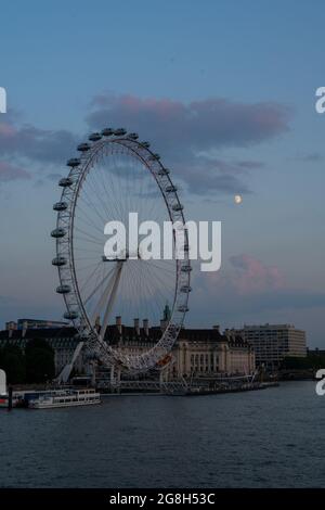 Southbank, London, Großbritannien. Juli 2021. Wetter in Großbritannien: Nach einem heißen und feuchten Tag in der Hauptstadt machen sich die Gewitterwolken klar, wenn der Mond nach Sonnenuntergang über dem London Eye aufgeht. Kredit: Celia McMahon/Alamy Live Nachrichten Stockfoto