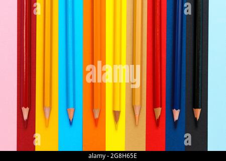 Ein Satz Buntstifte auf einem farbenfrohen Hintergrund. Eine Gruppe von hölzernen Buntstiften zum Zeichnen. Helle Farben Draufsicht Stockfoto