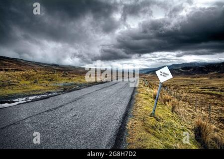 Ländliche, ländliche, schmale Autobahn in Schottland mit 'Passing Place'-Schild, Isle of Skye - Vereinigtes Königreich. Stockfoto