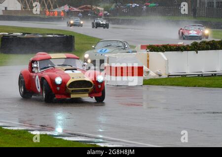 AC Cobra 289 Rennwagen-Rennen in einer Wet RAC Tourist Trophy beim Goodwood Revival Historic Event, Großbritannien. Konkurrierende Autos, die die Schikane nehmen Stockfoto