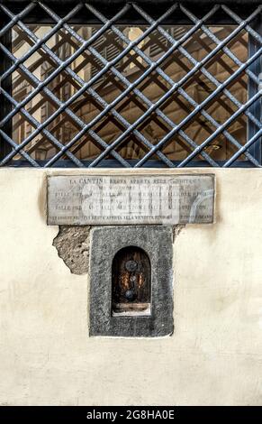 Weinfenster oder 'Buchetta del vino', eingebettet in die Seite eines jahrhundertealten Gebäudes, das in der Vergangenheit zum Verkauf von Wein in Florenz, der Toskana, Italien, genutzt wurde. Stockfoto