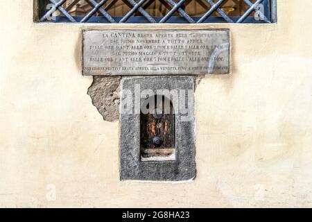 Weinfenster oder 'Buchetta del vino', eingebettet in die Seite eines jahrhundertealten Gebäudes, das in der Vergangenheit zum Verkauf von Wein in Florenz, der Toskana, Italien, genutzt wurde. Stockfoto