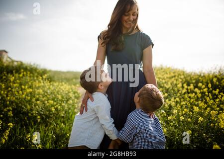 Mutter steht mit Söhnen im Wildflower-Feld Stockfoto