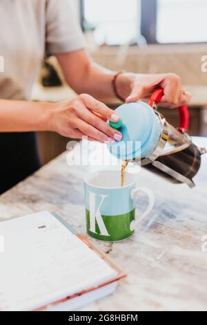 Nahaufnahme des Kaffees, der von der französischen Presse in die Tasse gegossen wurde Stockfoto