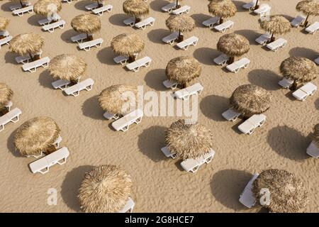 Luftaufnahme von Sonnenschirmen und Sonnenliegen am Sandstrand Stockfoto