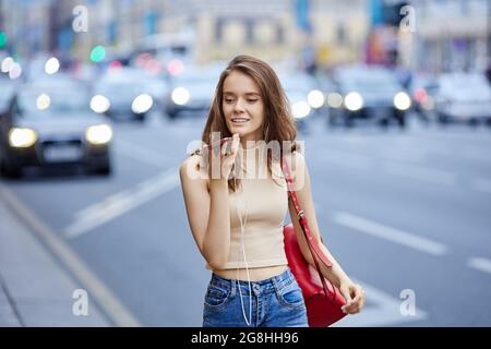 Schöne junge Frau verwendet Smartphone für Online-Gespräche im Freien. Stockfoto