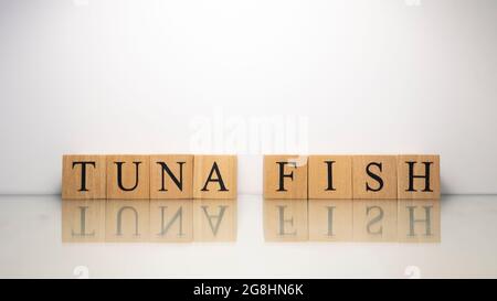 Thunfischphrase, die aus hölzernen Buchstabenwürfeln erstellt wurde. Meeresfrüchte und Essen. Nahaufnahme. Stockfoto