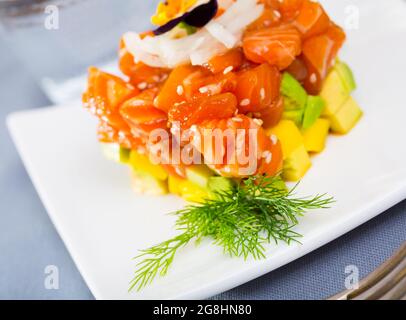Würzige Tartar aus rotem Fisch und Avocado auf dem Teller serviert Stockfoto