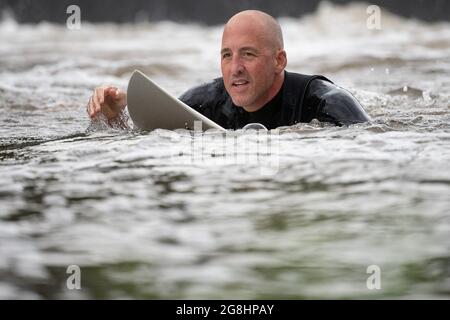 PRODUKTION - 12. Juli 2021, Hessen, Gießen: Paul Schmidt, Mitinitiator der Lahnwelle, paddelt am Wehr, wo die Surfwelle entstehen soll. (An dpa: 'Hessen statt Hawaii: 'Lahnwelle' sollte die Surfszene anziehen') Foto: Sebastian Gollnow/dpa Stockfoto