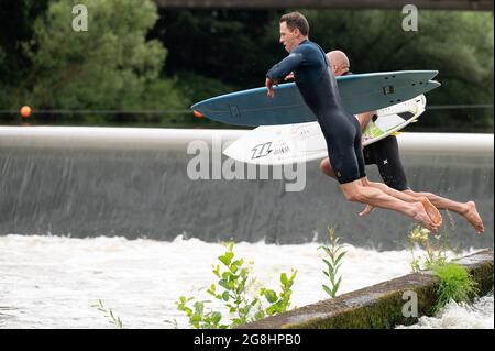 PRODUKTION - 12. Juli 2021, Hessen, Gießen: Surfer springen am Wehr in die Lahn, wo die Surfwelle entstehen soll. (An dpa: 'Hessen statt Hawaii: 'Lahn Wave' um die Surf-Szene anzuziehen') Foto: Sebastian Gollnow/dpa Stockfoto