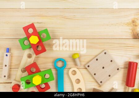 Ein farbenfroher Holzbausatz für Kinder auf Holz. Set von Werkzeugen auf Holztisch. Spiele und Werkzeuge für Kinder in der Vorschule oder Kindertagesstätte. Natürlich, umweltfreundlich Stockfoto