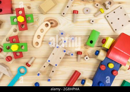 Ein farbenfroher Holzbausatz, ein Roboter für Kinder auf Holz. Set von Werkzeugen auf Holztisch. Spiele und Werkzeuge für Kinder in der Vorschule oder Kindertagesstätte. Natürlich, Stockfoto