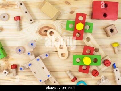 Ein farbenfroher Holzbausatz, ein Roboter für Kinder auf Holz. Set von Werkzeugen auf Holztisch. Spiele und Werkzeuge für Kinder in der Vorschule oder Kindertagesstätte. Natürlich, Stockfoto