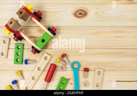 Ein farbenfroher Holzbausatz für Kinder auf Holz. Set von Werkzeugen auf Holztisch. Spiele und Werkzeuge für Kinder in der Vorschule oder Kindertagesstätte. Natürlich, umweltfreundlich Stockfoto