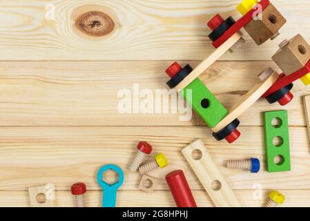 Ein farbenfroher Holzbausatz für Kinder auf Holz. Set von Werkzeugen auf Holztisch. Spiele und Werkzeuge für Kinder in der Vorschule oder Kindertagesstätte. Natürlich, umweltfreundlich Stockfoto