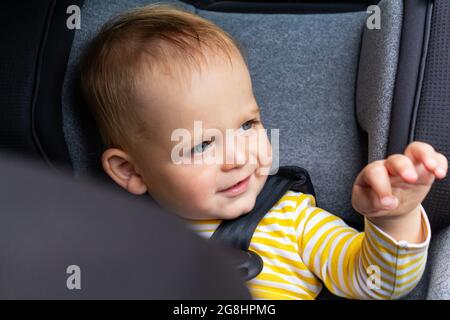 Baby auf dem Autositz Auf Wiedersehen vor der Abreise. Stockfoto