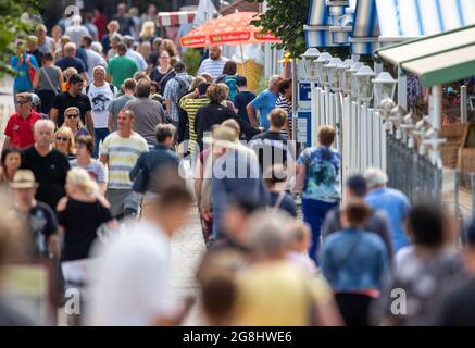 Zinnowitz, Deutschland. Juli 2021. Urlauber und Tagesbesucher sind auf dem Spaziergang zur Seebrücke auf der Ostseeinsel Usedom. Hotels, Pensionen und Campingplätze in Mecklenburg-Vorpommern sind in den kommenden Wochen gut ausgebucht. Nach Angaben des Tourismusverbandes könnte sich die Saison wie im vergangenen Jahr bis in den September erstrecken. Quelle: Jens Büttner/dpa-Zentralbild/dpa/Alamy Live News Stockfoto