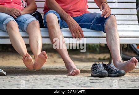 Zinnowitz, Deutschland. Juli 2021. Barfußurlauber sitzen auf einer Bank am Pier auf der Ostseeinsel Usedom. Hotels, Pensionen und Campingplätze in Mecklenburg-Vorpommern sind in den kommenden Wochen gut ausgebucht. Nach Angaben des Tourismusverbandes könnte sich die Saison wie im vergangenen Jahr bis in den September erstrecken. Quelle: Jens Büttner/dpa-Zentralbild/dpa/Alamy Live News Stockfoto