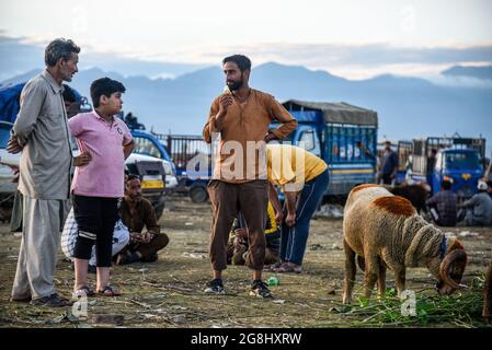 Srinagar, Indien. Juli 2021. Ein Schafsverkäufer kümmert sich vor dem Heiligen Fest um einen Kunden auf einem provisorischen Markt. Eid-ul-Adha wird am 21. Juli dieses Jahres in Indien und Pakistan beobachtet. In Saudi-Arabien wurde es heute am 20. Juli 2021 gefeiert. Es fällt in der Regel auf den zehnten Tag von Dhu al-Hijjah (der Monat der Pilgerfahrt für alle Muslime auf der ganzen Welt), der zwölften Monat des islamischen oder Mondkalenders Eid al-Adha. Kredit: SOPA Images Limited/Alamy Live Nachrichten Stockfoto