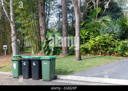 Müllcontainer für grüne Vegetation in einer Straße in Sydney, die auf die Abholung durch den australischen Müllwagen durch den rat warten Stockfoto