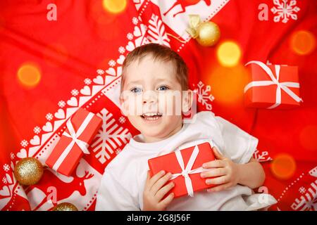 Weihnachtsmann Kleinkind liegt auf dem Rücken mit Weihnachtsgeschenk. Stockfoto