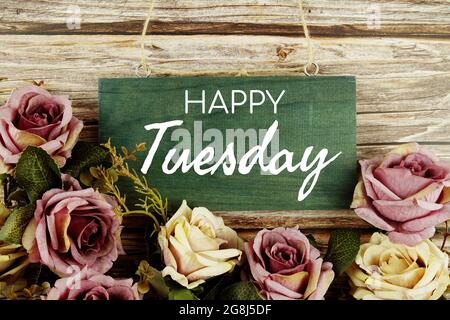 Happy Tuesday Typografie Text mit rosa Rosen Blumen Blumenstrauß auf hölzernem Hintergrund Stockfoto