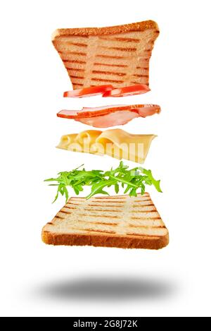 Zutaten für Sandwich fliegen über den Tisch auf weißem Hintergrund. Kreatives Food-Konzept Stockfoto