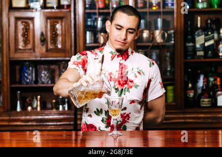 pro-Barkeeper bereiten Coctail-Drinks zu und repräsentieren das Nachtleben und das Partyevent-Konzept. Stockfoto
