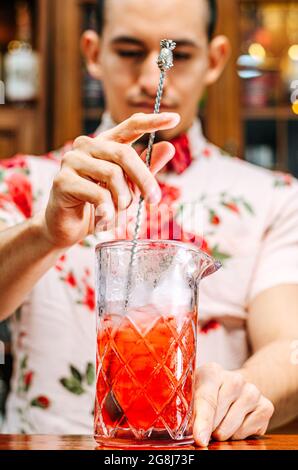 pro-Barkeeper bereiten Coctail-Drinks zu und repräsentieren das Nachtleben und das Partyevent-Konzept. Stockfoto