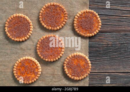 Kekse mit Schokolade und Orangenmarmelade auf dunklem Holzhintergrund, Draufsicht Stockfoto