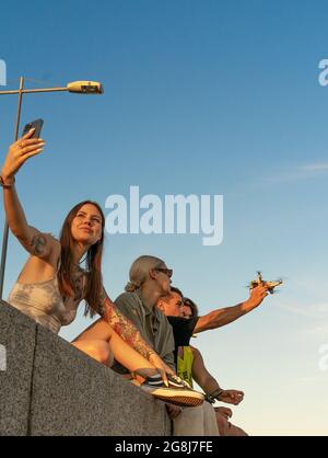 Junge Frau, die ein Foto von einem Mann, der seine Drohne fangen Stockfoto