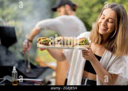 Freunde machen Burger auf einem Picknick Stockfoto