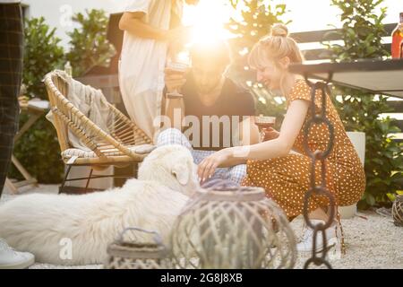Freunde mit Hund und Getränke im Hinterhof Stockfoto