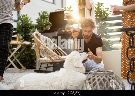 Freunde mit Hund und Getränke im Hinterhof Stockfoto