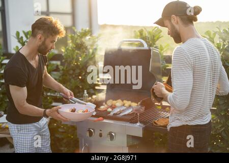 Kerl beim Gartenessen bei Sonnenuntergang Stockfoto