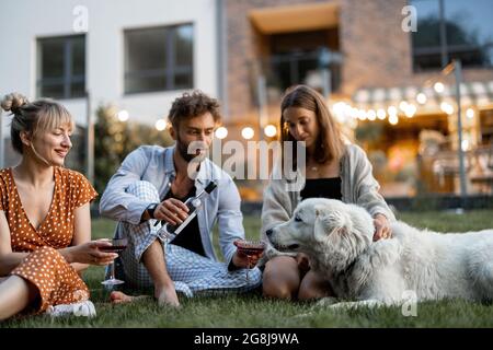 Freunde, die am Abend im Hinterhof Spaß haben Stockfoto