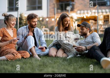 Freunde, die am Abend im Hinterhof Spaß haben Stockfoto