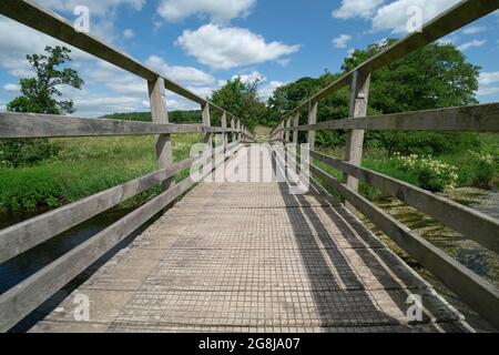 Holzbrücke über den Fluss Lowther auf der Lowther Loop des Ullswater Way, zwischen Whale und Helton, Cumbria Stockfoto