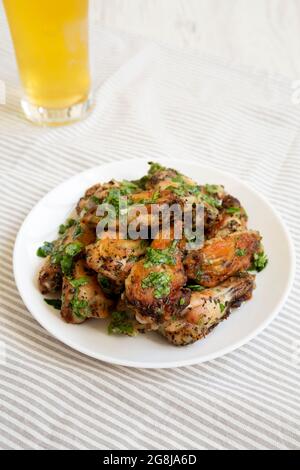 Hausgemachter Knoblauch Parmesan Chicken Wings mit kaltem Bier, Blick aus der unteren Ecke. Stockfoto