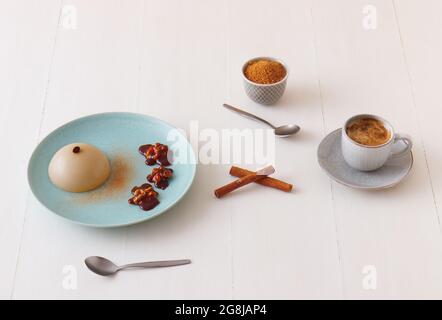 Espresso Panna Cotta mit Walnüssen in Karamell, Tasse Kaffee und Schüssel mit Zuckerrohr. High-Angle-Ansicht. Stockfoto